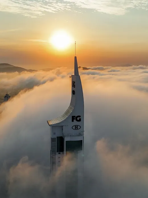 Captação aérea com drone — torre acima das nuvens ao pôr do sol